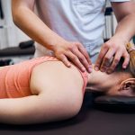 Young woman getting neck, head massage in therapy room.