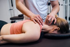 Young woman getting neck, head massage in therapy room.